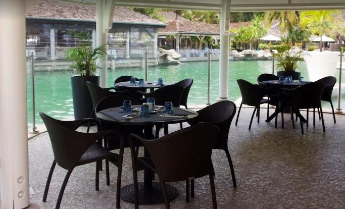 Tables et chaises du restaurant Lux Saint Gilles avec vue sur le lagon turquoise de La Réunion